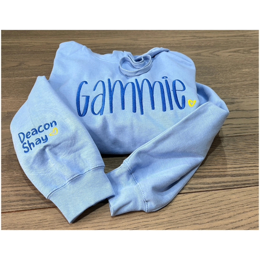 Light blue hoodie with 'Gammie' and 'Deacon Shay' text on a wooden surface