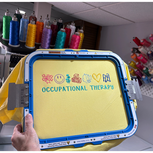 Yellow sweatshirt with 'Occupational Therapy' text and symbols on an embroidery hoop.