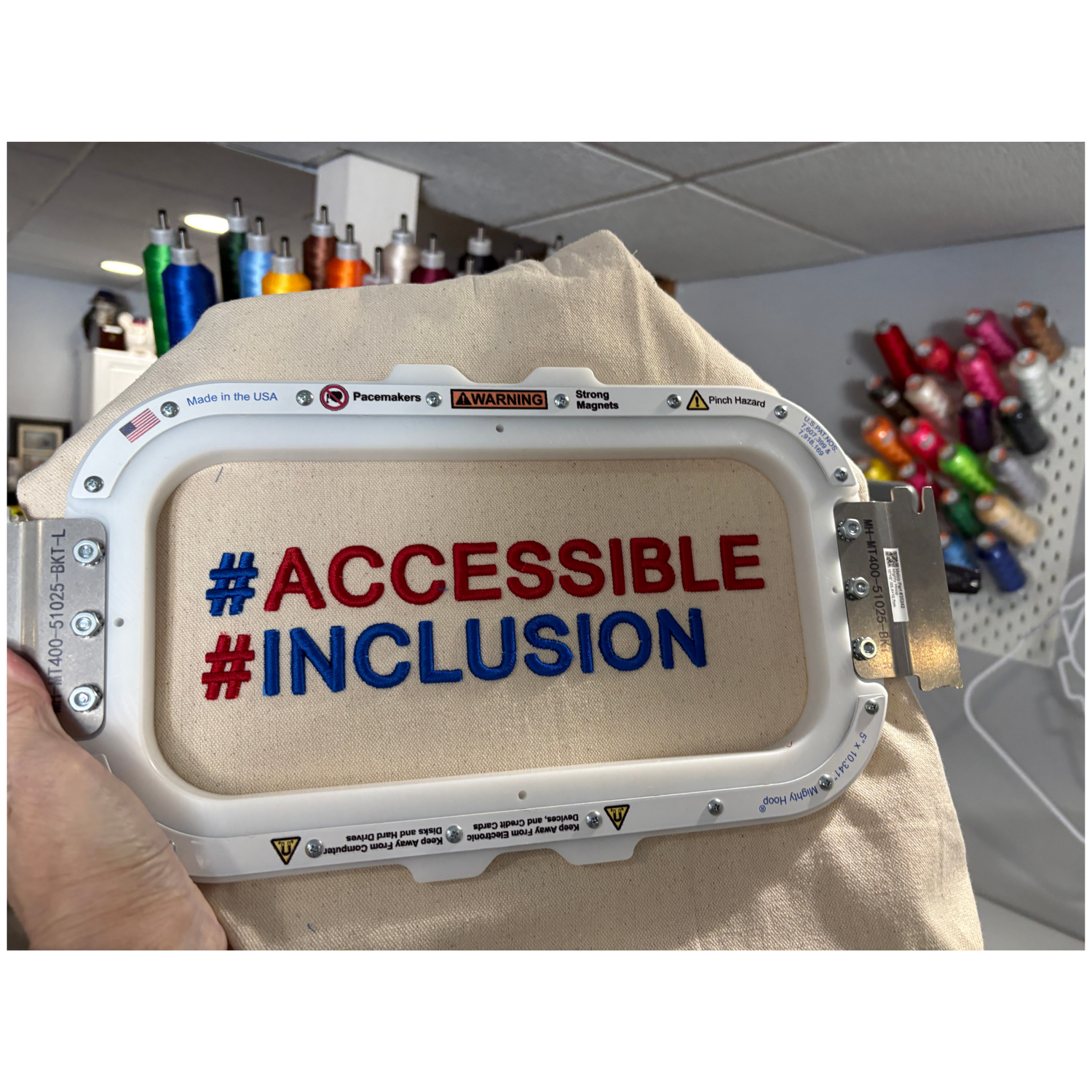 white tote inside an embroidery hoop with the words #accessible # inclusion