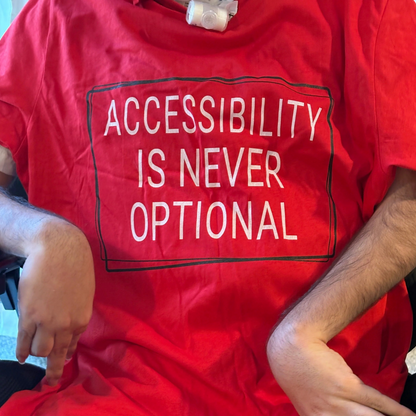 Person wearing a red shirt with 'ACCESSIBILITY IS NEVER OPTIONAL' text.