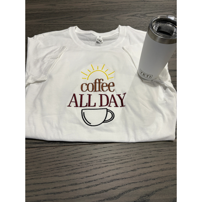 White t-shirt with 'Coffee All Day' design and a Yeti tumbler on a wooden surface