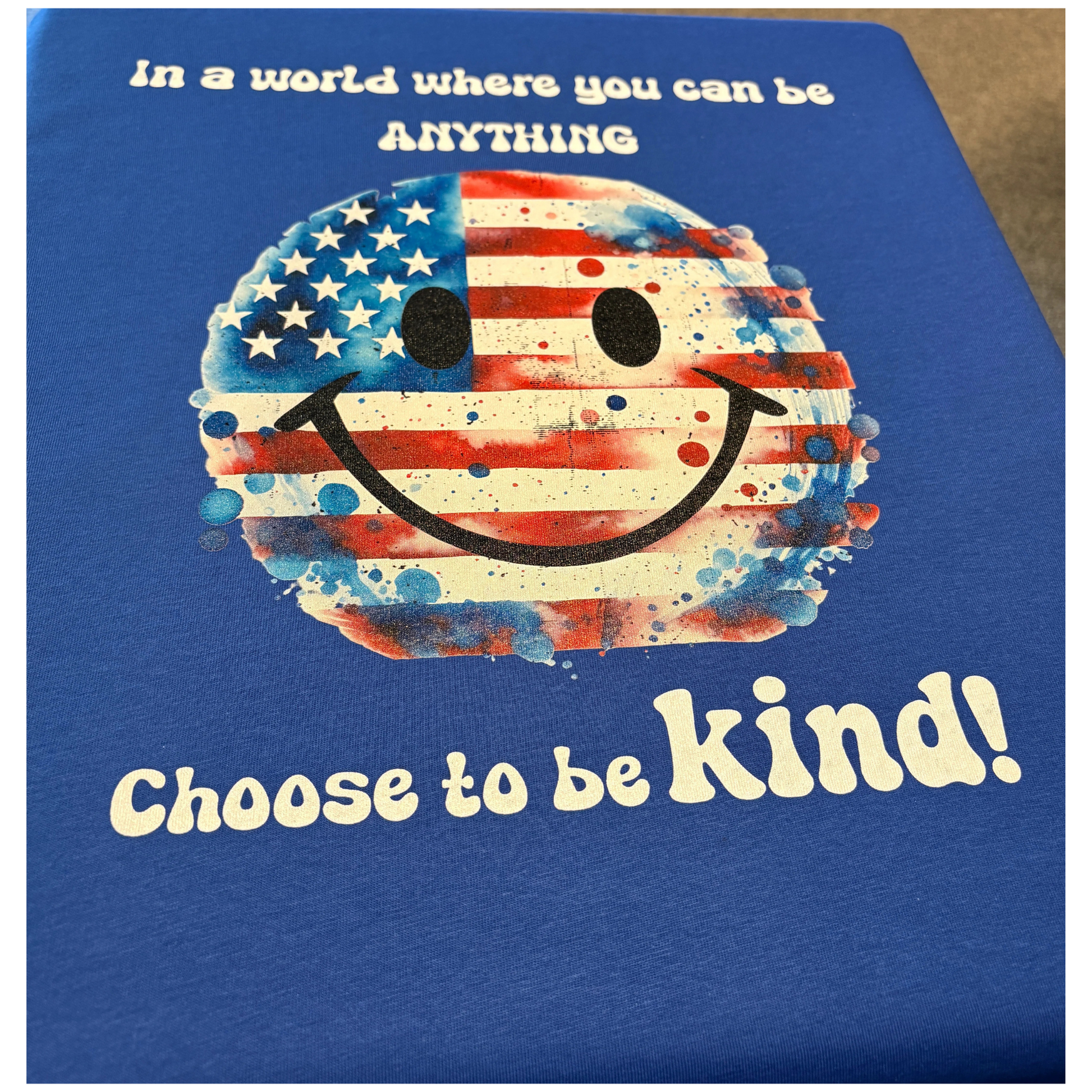 Blue sweatshirt with a smiley face design featuring the American flag and text 'Choose to be kind!' on a blue background.
