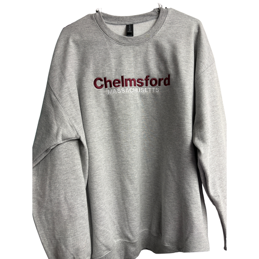 A heather gray crew sweatshirt with 'Chelmsford Massachusetts' embroidered across the chest in maroon and white lettering.