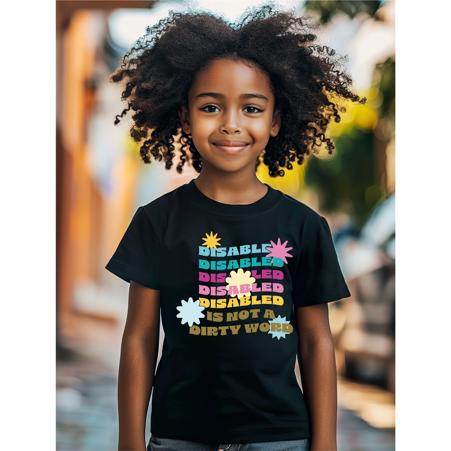 Child wearing a black t-shirt with colorful text in an outdoor setting