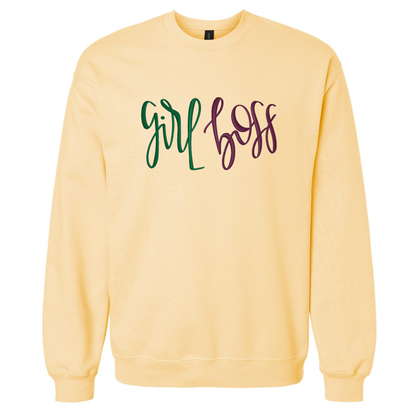 A pale yellow crewneck sweatshirt featuring the text 'girl boss' embroidered across the chest in green and dark purple script.