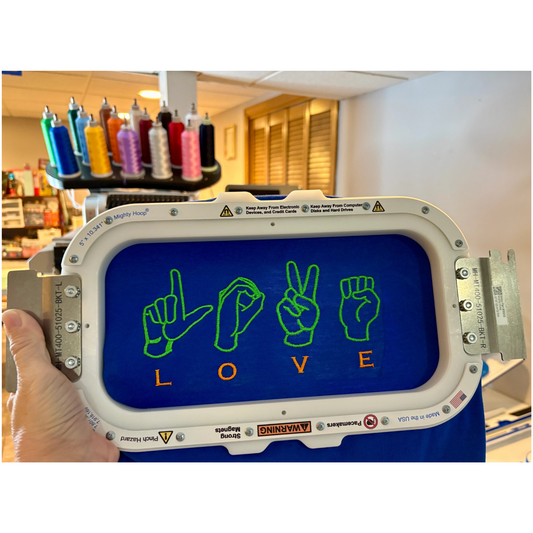 Machine with a digital display showing 'LOVE' in sign language, held by a person.