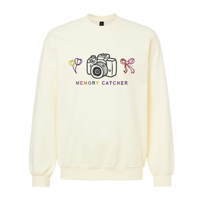 Cream-colored sweatshirt with a camera graphic and 'Memory Catcher' text on a white background
