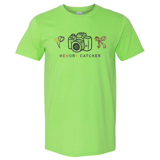 Lime green t-shirt with camera and flower graphic and 'Memory Catcher' text on a white background