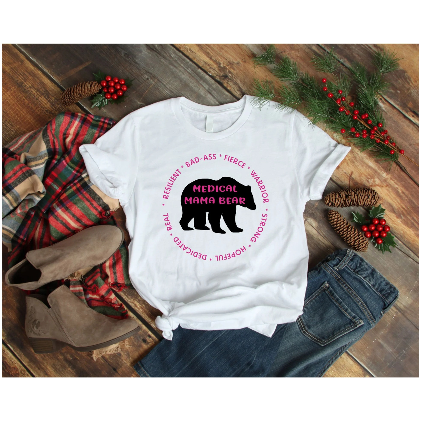 White t-shirt with bear graphic and text on a wooden surface with festive decorations
