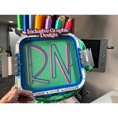 3D printing process with 'RN' design on a green material, held by a hand.