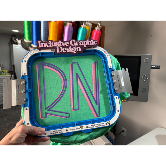 3D printing process with 'RN' design on a green material, held by a hand.