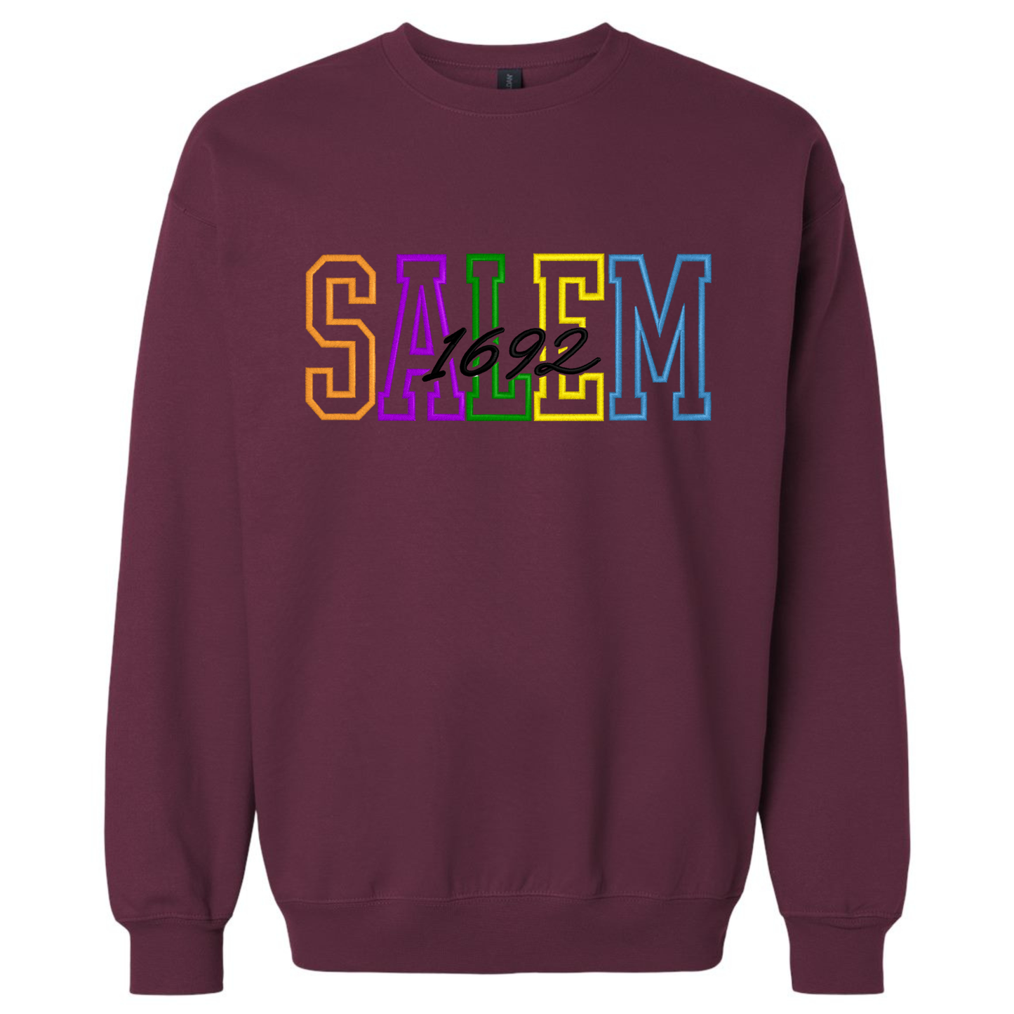 A maroon crewneck sweatshirt with Embroidered Letters on the chest that reads 'SALEM 1692' in Halloween-colored block letters.