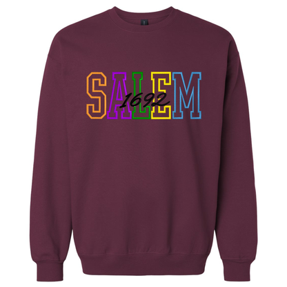 A maroon crewneck sweatshirt with Embroidered Letters on the chest that reads 'SALEM 1692' in Halloween-colored block letters.