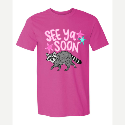The Words See Ya Soon with a Raccoon printed on a pink tshirt